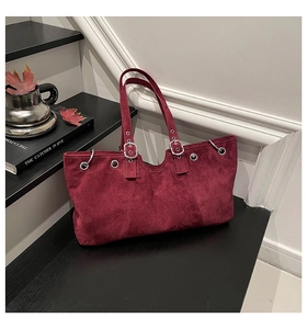 Detailed view of burgundy vintage tote bag with metal eyelets and strap details