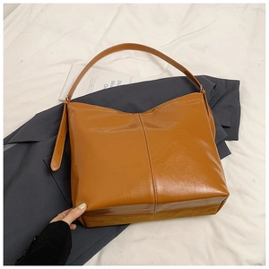 Détail du sac fourre-tout caramel montrant la texture brillante et la couture blanche