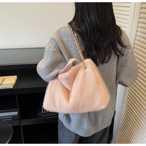 Detail showing plush pink faux fur tote bag with metal chain strap and leather handle