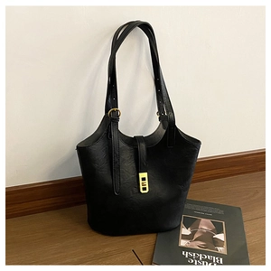 Detail of black PU leather tote showing textured surface and golden rectangular buckle