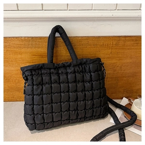 Détail du sac fourre-tout matelassé noir avec poignées bouffantes et bandoulière chic