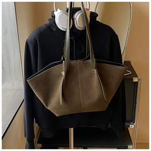 Close-up of deep olive suede tote bag showing its unique wide trapezoidal texture and long handles