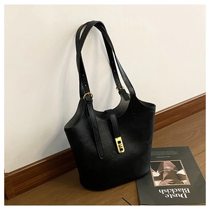 Detail of adjustable double straps with golden metal buckles on black PU tote bag