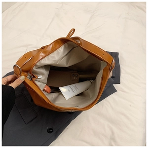 Macro view of brown tote bag interior showing large capacity and zipper pocket