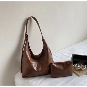 Macro detail of brown leather tote bag texture with matching mini pouch and metal buckle