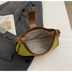 Top view showing the spacious grey interior and zippered pocket of the green suede bag