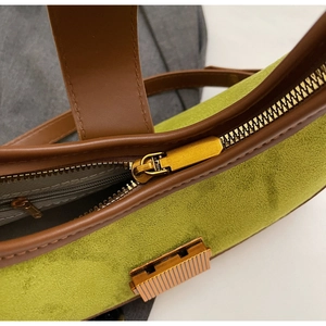 Detailed macro view of the avocado green suede fabric and golden zipper on the bag