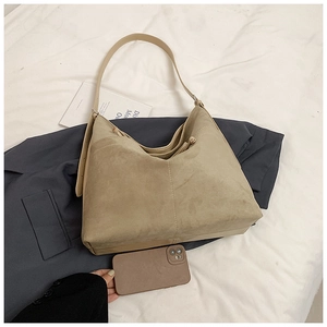 Macro view of beige matte suede tote bag with fine stitching and adjustable shoulder strap