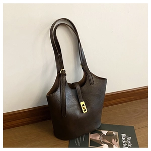 Detailed macro view of dark brown leather tote bag texture with golden metal buckle