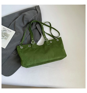 Macro detail of grass green suede tote bag with silver eyelets and buckle decoration