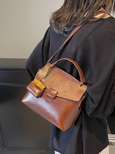 Vintage brown leather crossbody handbag with micro bag accessory for women in 2025 style