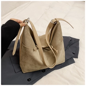 Détail du sac cabas en daim kaki montrant la poche latérale, le cordon et la bandoulière