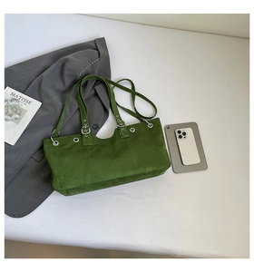 Detail view of dark green suede tote bag with silver grommet straps and vintage stitching