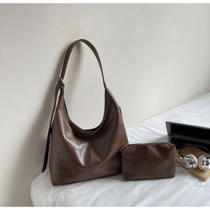 Detail of dark brown faux leather hobo bag with matching mini zippered coin purse