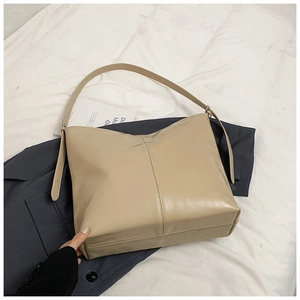 Détail de la texture en similicuir beige lisse et couture verticale du grand sac cabas