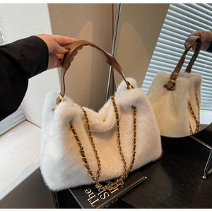 Detail of white faux fur handbag with brown leather handle and gold chain strap