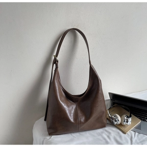 Close-up of brown large Hobo bag with natural leather texture and vertical stitch detail
