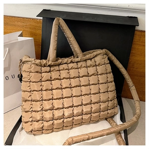 Détail du sac cabas matelassé beige avec surpiqûres carrées et finition satinée