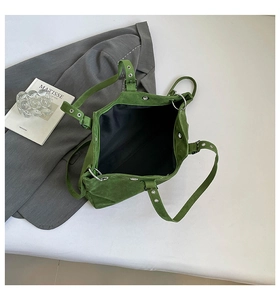 Top view of spacious green suede tote bag with adjustable strap on a minimalist background