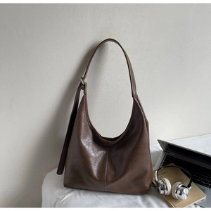 Detailed view of deep brown hobo tote bag with vintage leather texture and silver buckle
