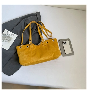 Spacious yellow suede tote bag with metal eyelets showing storage capacity and scale