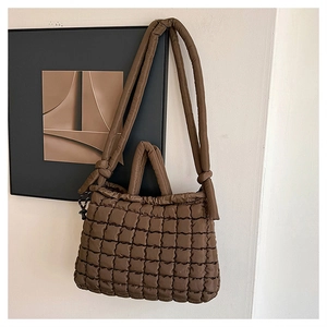 Détail du sac cabas matelassé marron foncé avec bandoulière nouée et fermeture à cordon