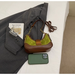 Brown and green leather crossbody bag shown with a smartphone for size comparison