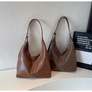 Texture detail of soft leather hobo bags in caramel and dark coffee brown colors