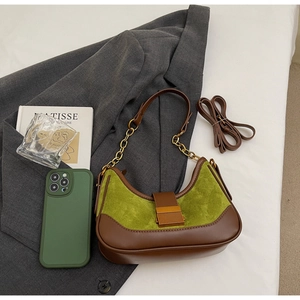 Detalle del bolso de ante verde oliva con cadena dorada y opción de doble correa
