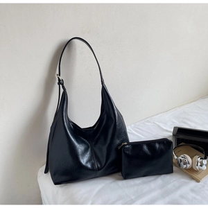 Detail of minimalist black hobo bag and small zipper pouch in premium pebbled leather