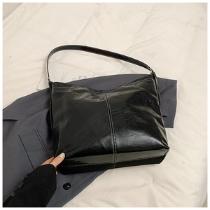 Détail du sac en cuir verni noir avec surpiqûres blanches contrastées élégantes