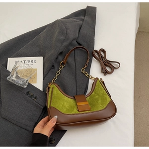 Detail of avocado green suede underarm bag with vintage gold buckle and chain strap
