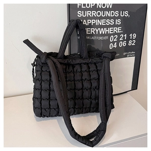 Détail du sac cabas matelassé noir avec texture à bulles et poignée rembourrée confortable
