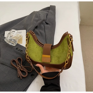 Detail of green suede and brown leather hobo bag with gold buckle and chain strap