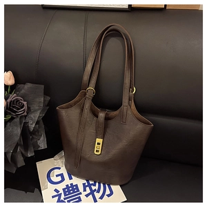 Close-up of deep brown leather tote bag with elegant golden twist lock and dual strap details