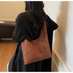Detail of the large caramel suede tote bag with silver metal ring and drawstring knot