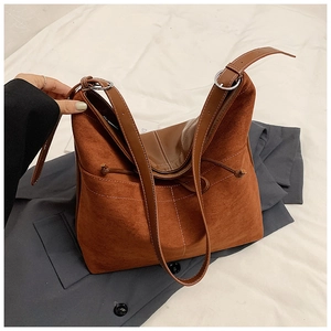 Vue détaillée du sac cabas en daim marron avec surpiqûres blanches et boucles argentées