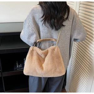 Close-up of the plush faux fur texture and gold chain strap of this khaki shoulder bag