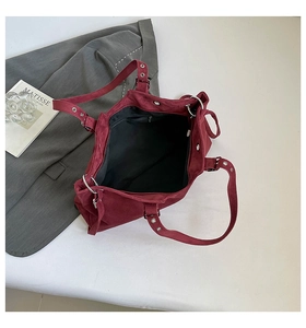 Interior detail of red suede tote bag showing zipper pocket and magnetic closure