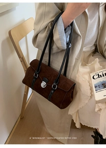 Close-up of vintage dark brown suede baguette bag with elegant silver buckle and thin straps