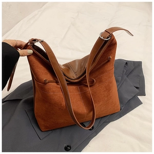Détail du sac cabas en daim caramel avec surpiqûres blanches et boucles argentées