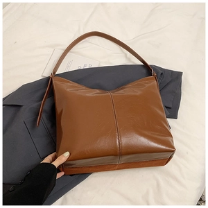 Macro shot of dark brown PU leather tote with stylish white contrast stitching details