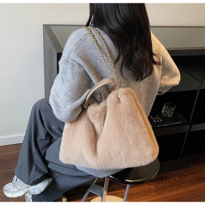 Detail of plush tote bag in khaki faux fur featuring gold chain and leather handle