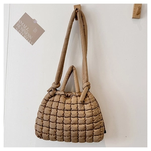 Détail du sac cabas matelassé kaki avec poignée à nœud sur un crochet en bois