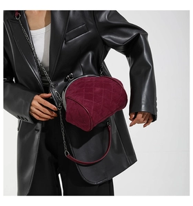 Close-up of wine red quilted velvet crossbody bag with vintage metal frame and chain strap