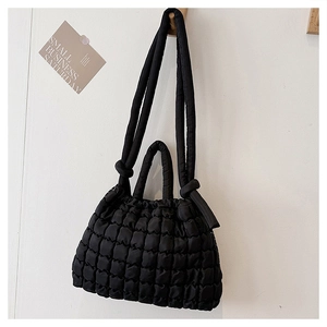 Détail du sac matelassé noir avec double bandoulière et texture douce style nuage