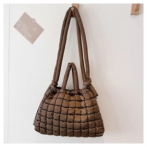 Détail du sac fourre-tout matelassé marron foncé avec texture gaufrée et anses souples