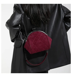 Detail of burgundy quilted chain bag worn with black leather jacket for a vintage look