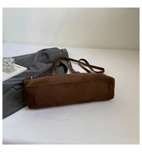 Close-up of matte coffee brown tote bag with metal eyelets and suede texture detail