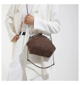 Detail of coffee brown quilted chain bag with vintage metal clasp and matte texture